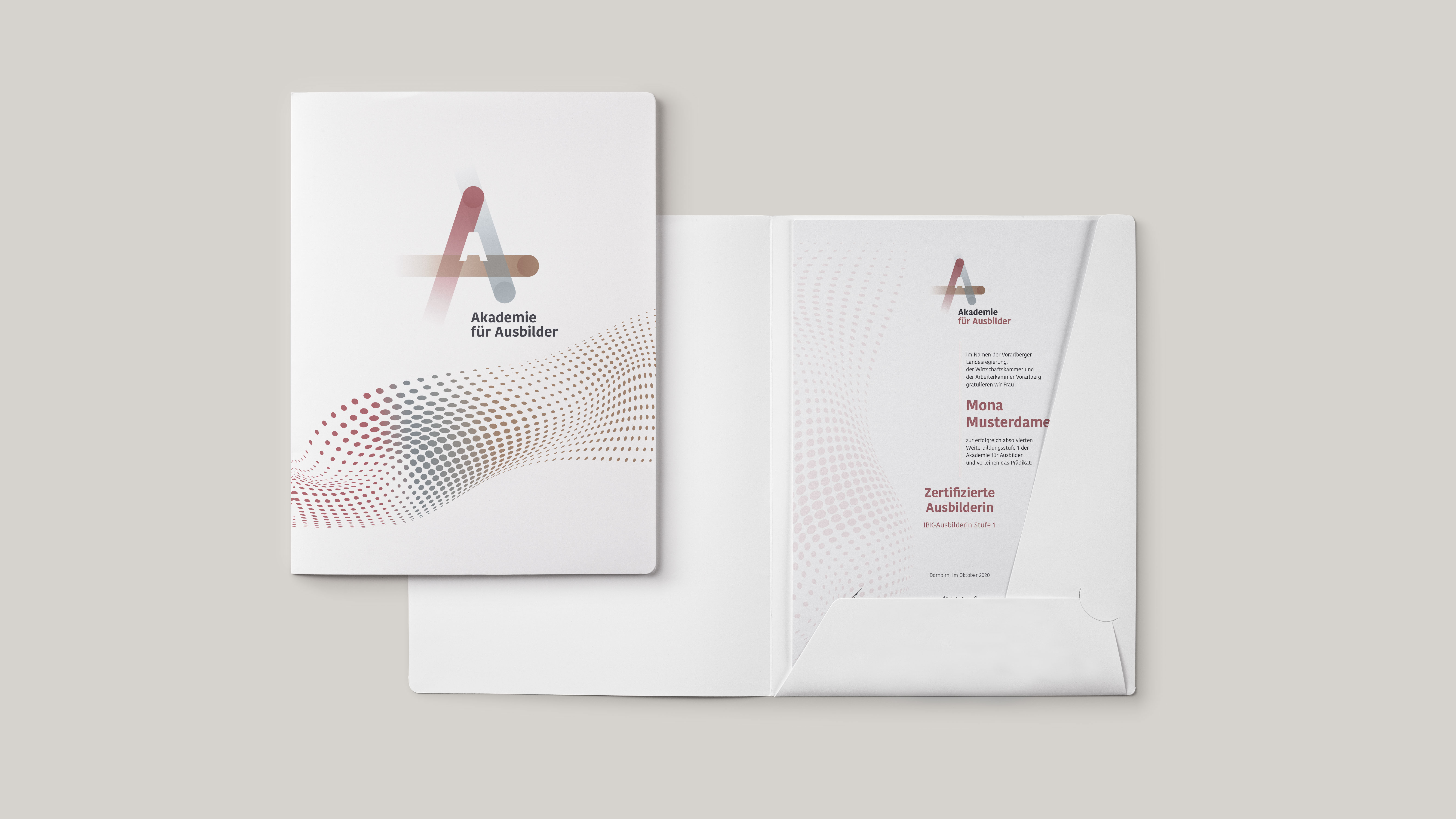 ausbilder_mappe_mit_urkunde.jpg Weiße Mappe offen und geschlossen mit Logo Akademie für Ausbilder