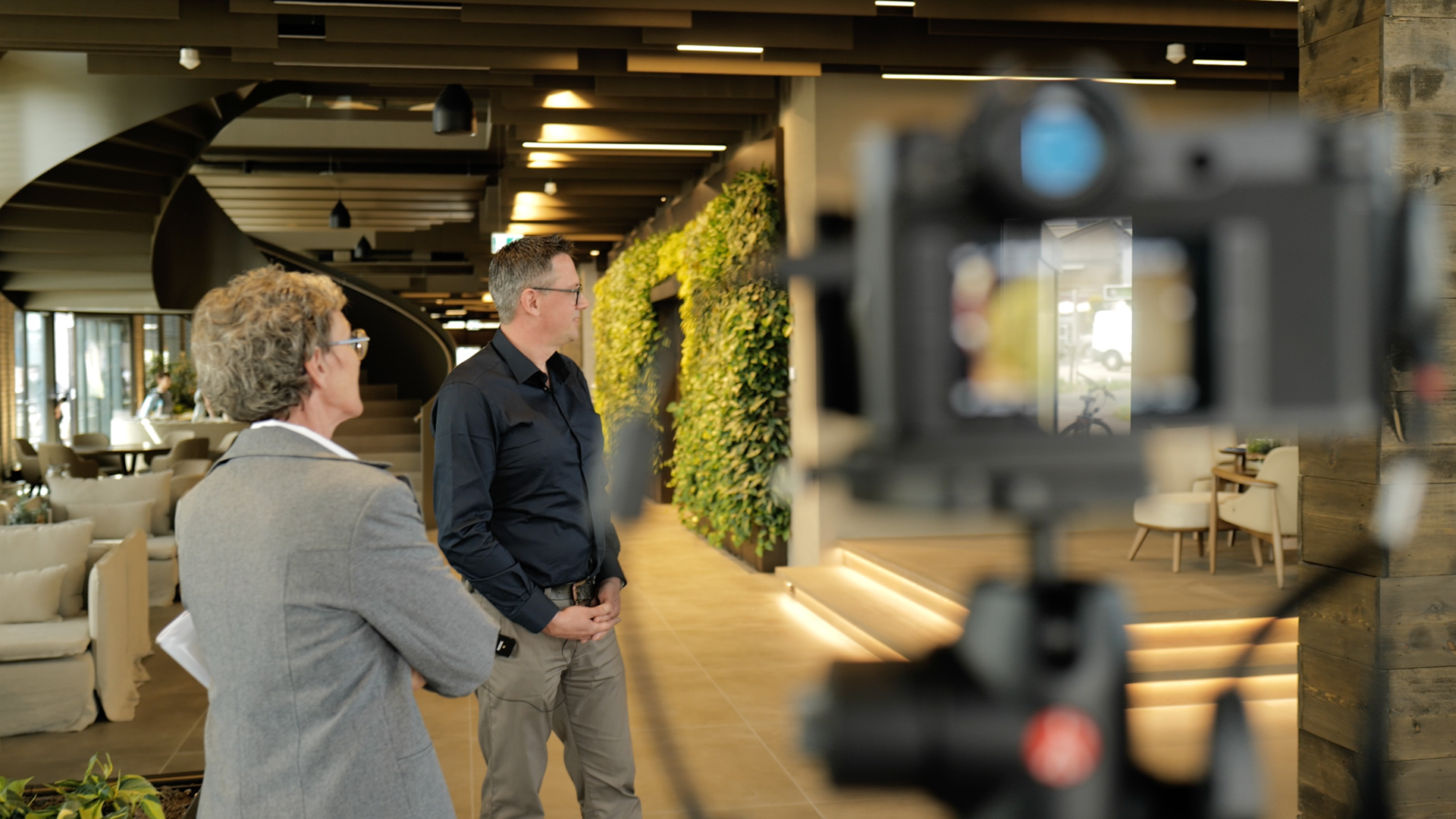 Eine Kamera filmt das Interview zum Top Projekt "Haus der Wirtschaft". Maria Linder interviewt den Architekten.
