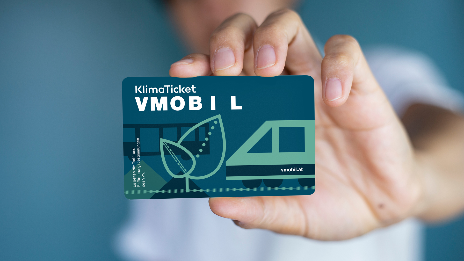 vmobil-header-02.jpg Ein Mann hält ein KlimaTicket VMOBIL in die Kamera.