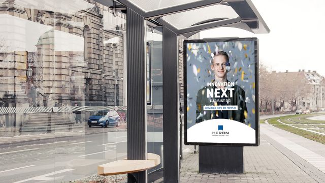 Poster Heron Lehrlingskampagne an Bushaltestelle junger Mann hinter goldenem Konfetti mit Aufschrift Innovation Next das bist du